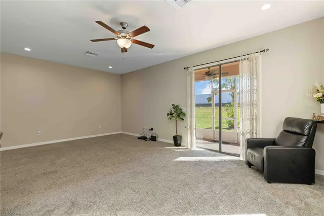 a view of an empty room with a ceiling fan and window
