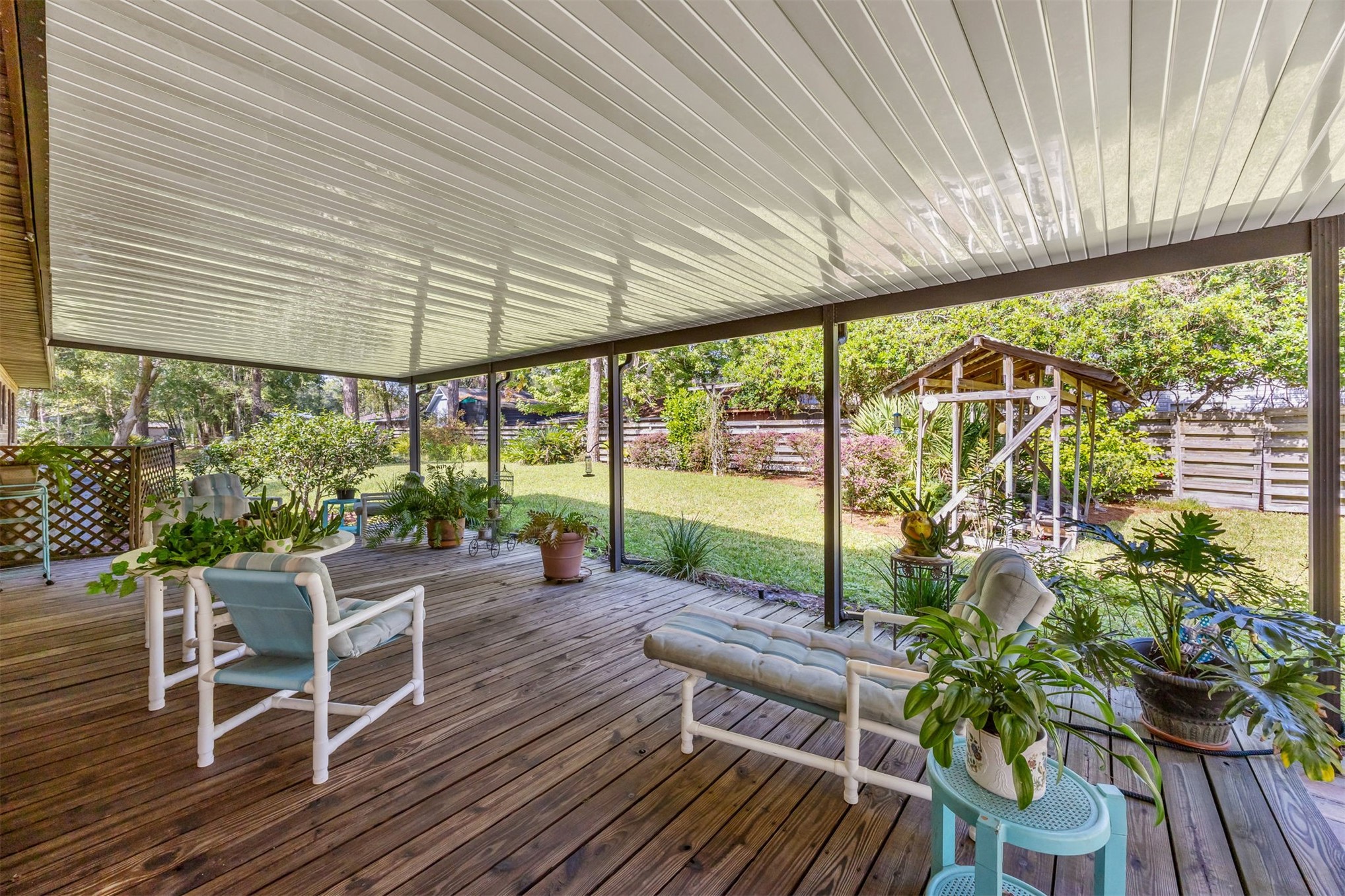 96111 Pirates Bluff Road Yulee, FL 32097 - Photo 28 of 52 a view of a patio with table and chairs potted plants and floor to ceiling window