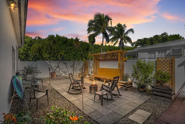 a view of a patio with table and chairs and potted plants with wooden floor and fence