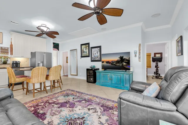 a kitchen with stainless steel appliances kitchen island granite countertop a dining table chairs and a refrigerator