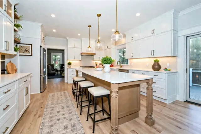 a kitchen with kitchen island a sink table and chairs