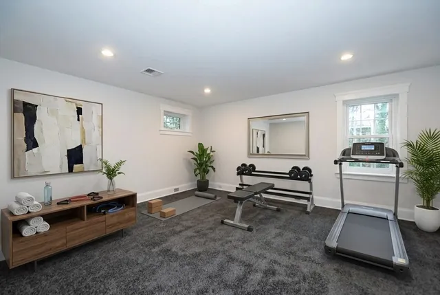 a living room with furniture gym equipment and a window