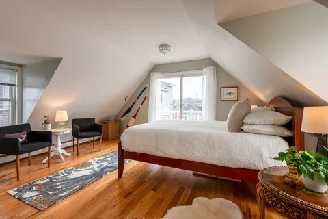 a bedroom with furniture and wooden floor