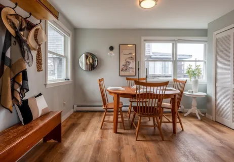 a view of a dining room with furniture a chandelier and wooden floor