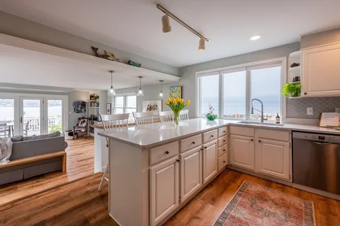 a living room with furniture two window and a flat screen tv