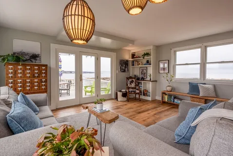 a living room with furniture fireplace and a large window