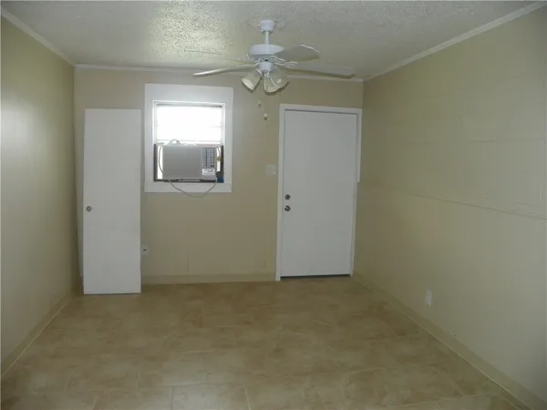 an empty room with windows and fan