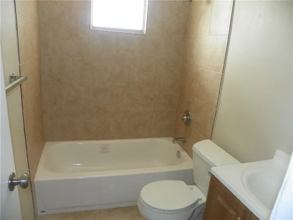 a white toilet sitting next to a bath tub