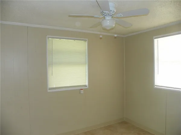 an empty room with a window and a fan