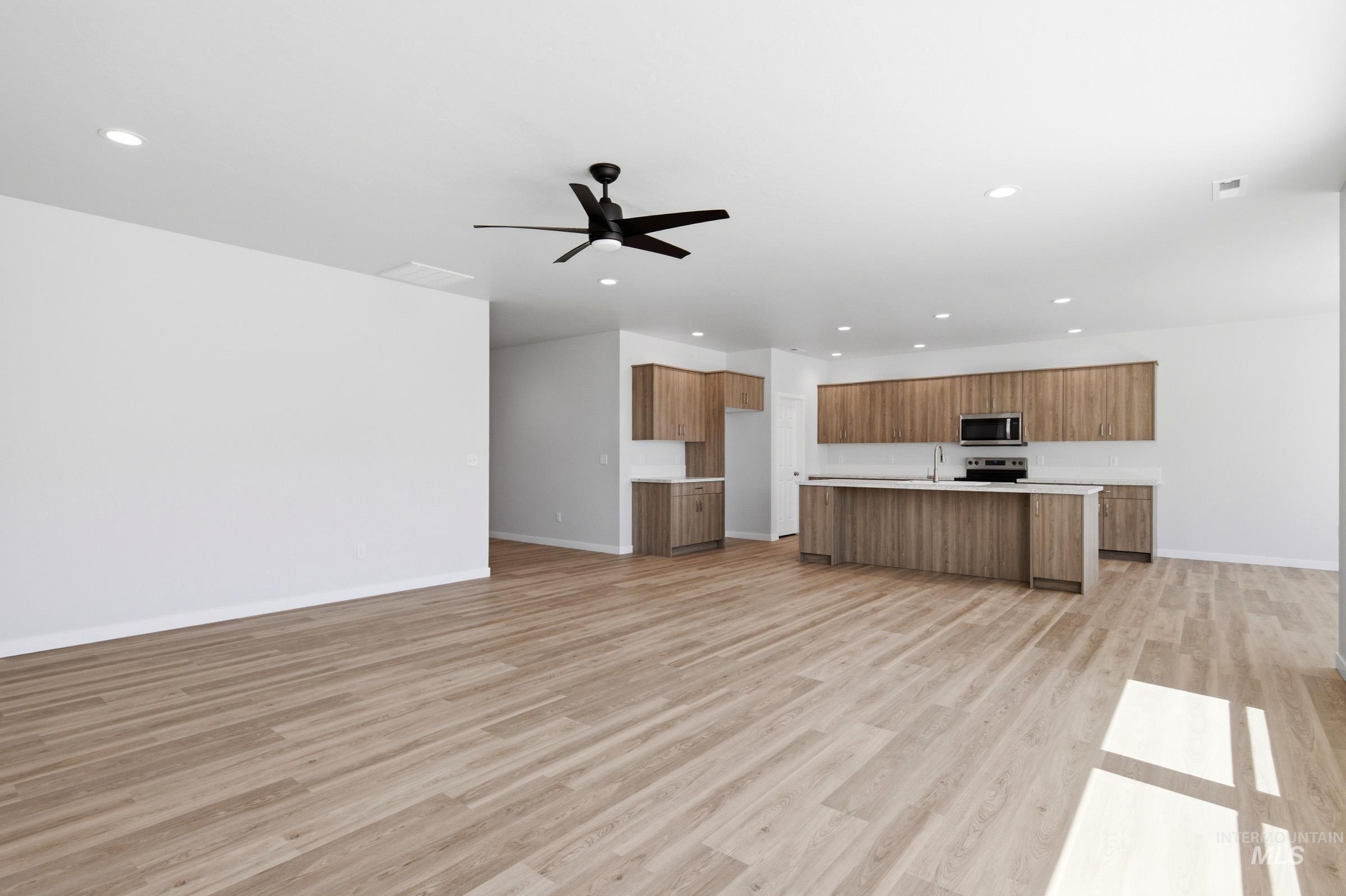 13649 Inman Court Caldwell, ID 83607 - Photo 13 of 22 Spacious open-concept interior featuring light wood-finish flooring, recessed lighting, and a modern ceiling fan