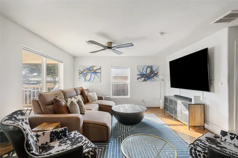 a living room with furniture a flat screen tv and a large window
