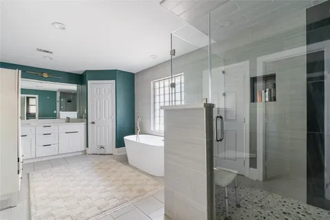 a bathroom with a tub shower and sink