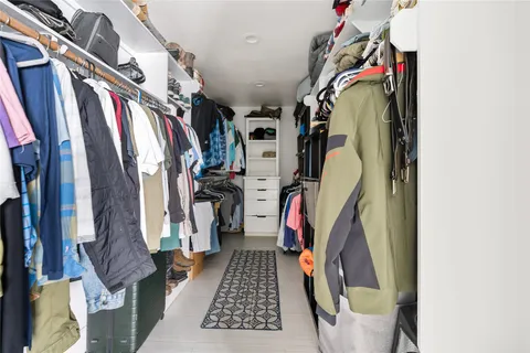 a view of walk in closet with clothes and shoes
