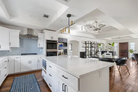 a large kitchen with kitchen island a large counter space a sink stainless steel appliances and cabinets