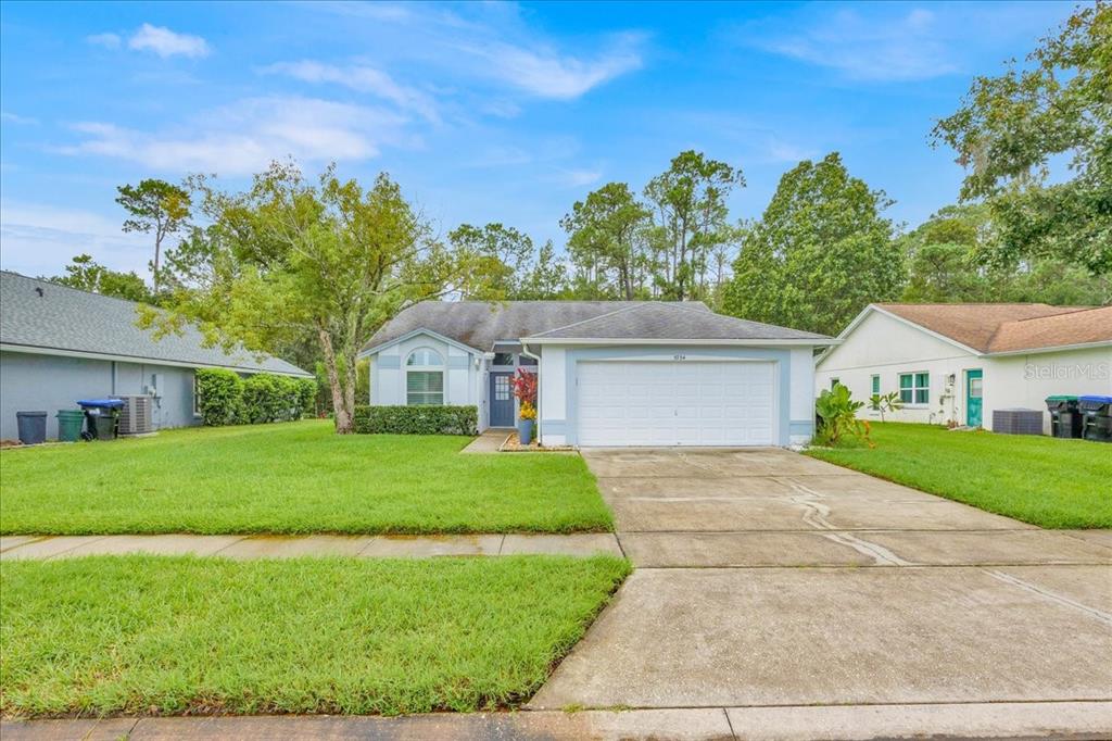 5734 Delano Lane Orlando, FL 32821 - Photo 1 of 28 a front view of a house with a yard and garage