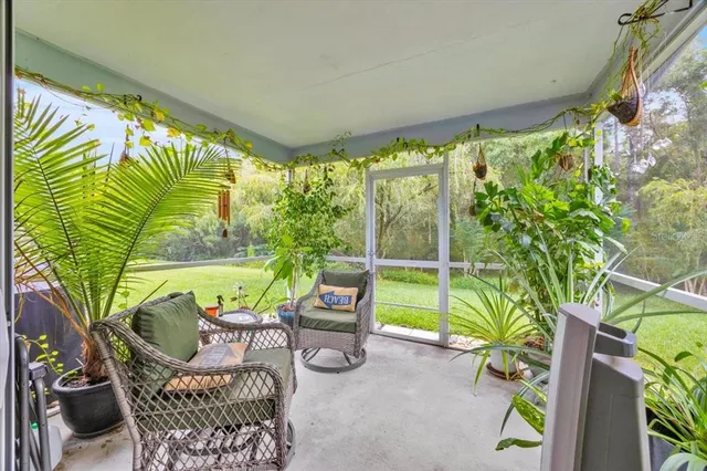 a view of a porch with furniture and a yard