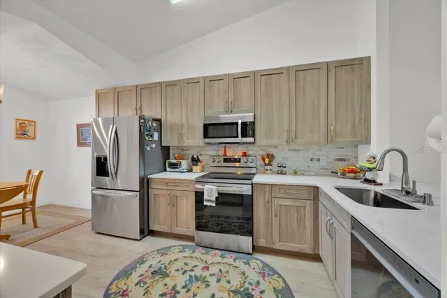 a kitchen with cabinets stainless steel appliances and a sink