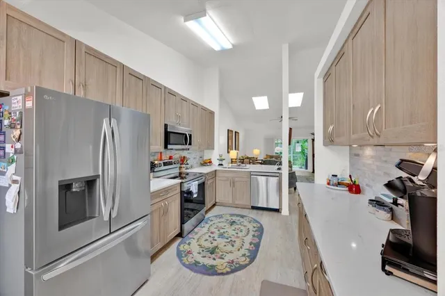 a kitchen with a refrigerator a stove top oven a sink and cabinets