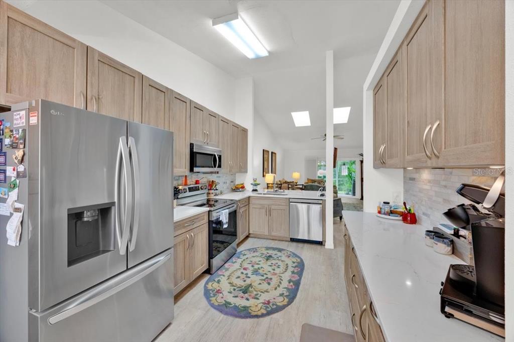 5734 Delano Lane Orlando, FL 32821 - Photo 8 of 28 a kitchen with a refrigerator a stove top oven a sink and cabinets