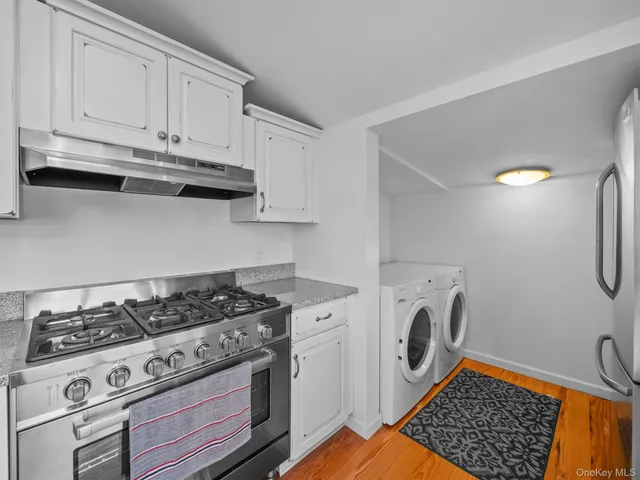 a kitchen with granite countertop a stove top oven a sink a dining table and chairs