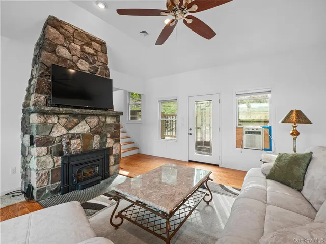 a living room with furniture ceiling fan and a wooden floor