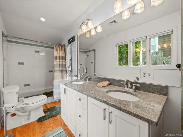 a bathroom with a granite countertop sink a large mirror and a shower