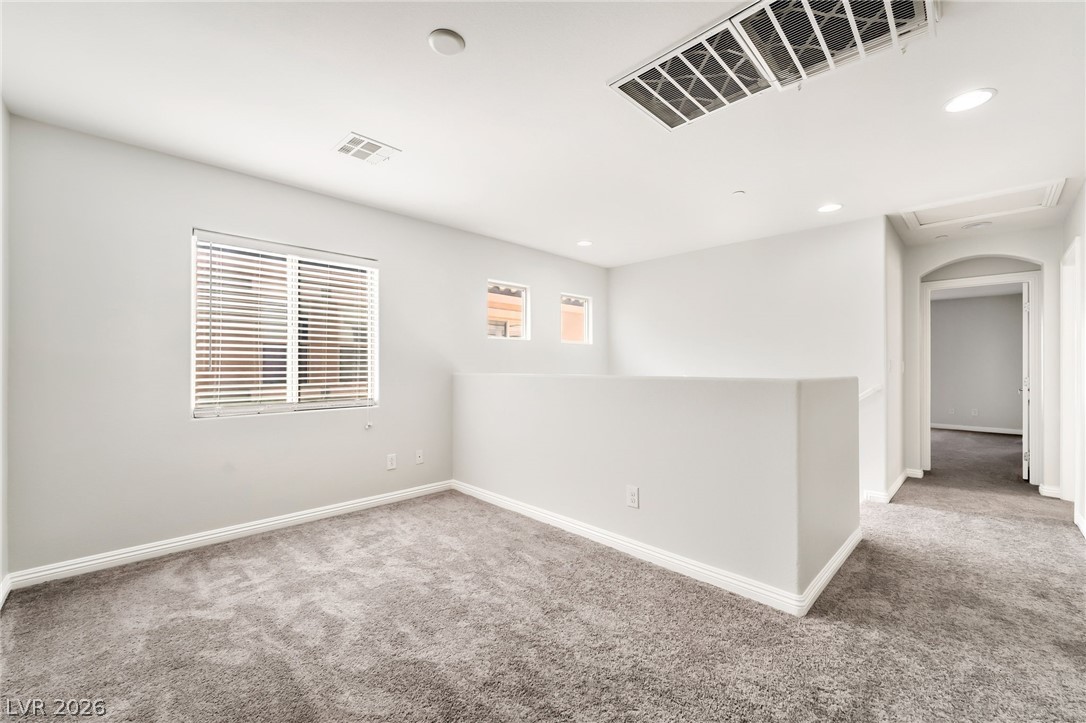 33 Jasmine Point Street Henderson, NV 89074 - Photo 13 of 36 Empty room with light colored carpet and recessed lighting
