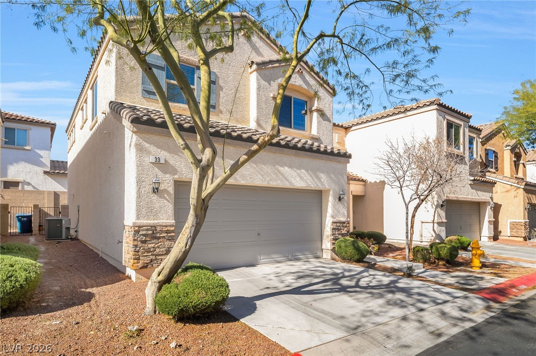 33 Jasmine Point Street Henderson, NV 89074 - Photo 3 of 36 Mediterranean / spanish-style home with stucco siding, an attached garage, concrete driveway, and stone siding