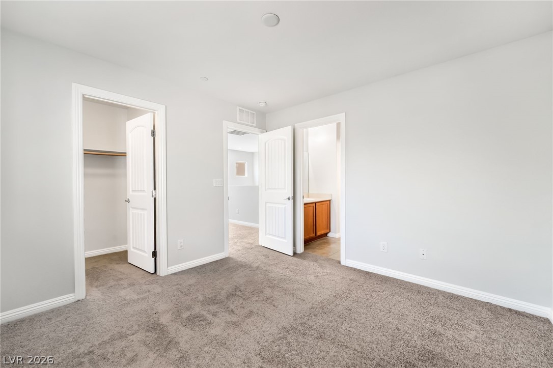 33 Jasmine Point Street Henderson, NV 89074 - Photo 30 of 36 Unfurnished bedroom with a walk in closet, light colored carpet, and ensuite bath