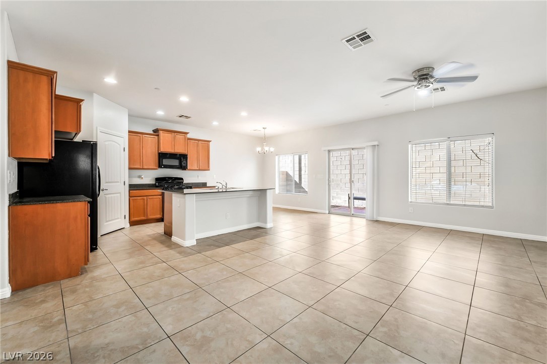 33 Jasmine Point Street Henderson, NV 89074 - Photo 36 of 36 Kitchen featuring dark countertops, open floor plan, ceiling fan, a chandelier, and black appliances