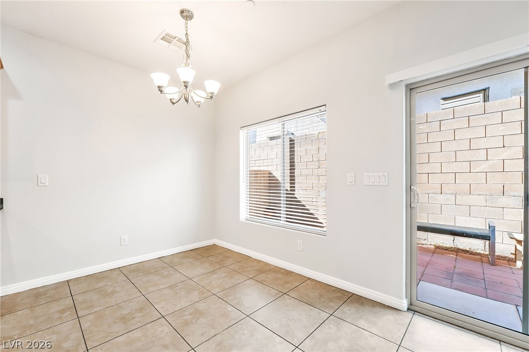 33 Jasmine Point Street Henderson, NV 89074 - Photo 6 of 36 Unfurnished dining area featuring a chandelier, light tile patterned floors, and a fireplace