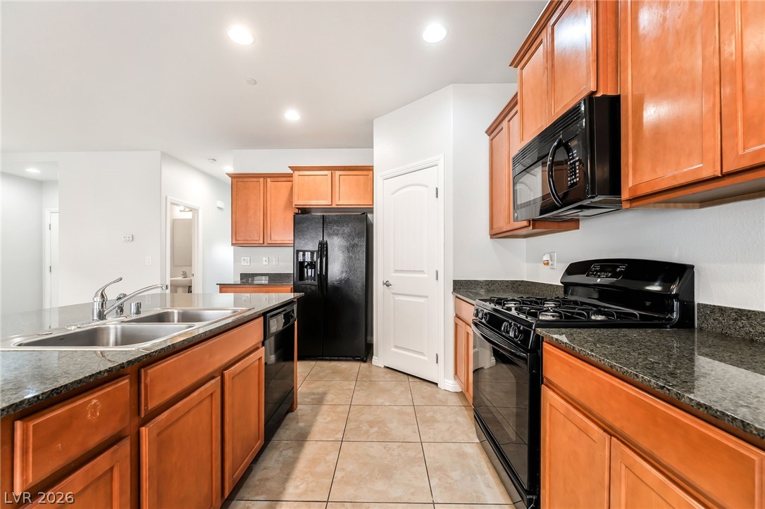 33 Jasmine Point Street Henderson, NV 89074 - Photo 8 of 36 Kitchen featuring black appliances, wood finish cabinetry, light tile patterned floors, and recessed lighting