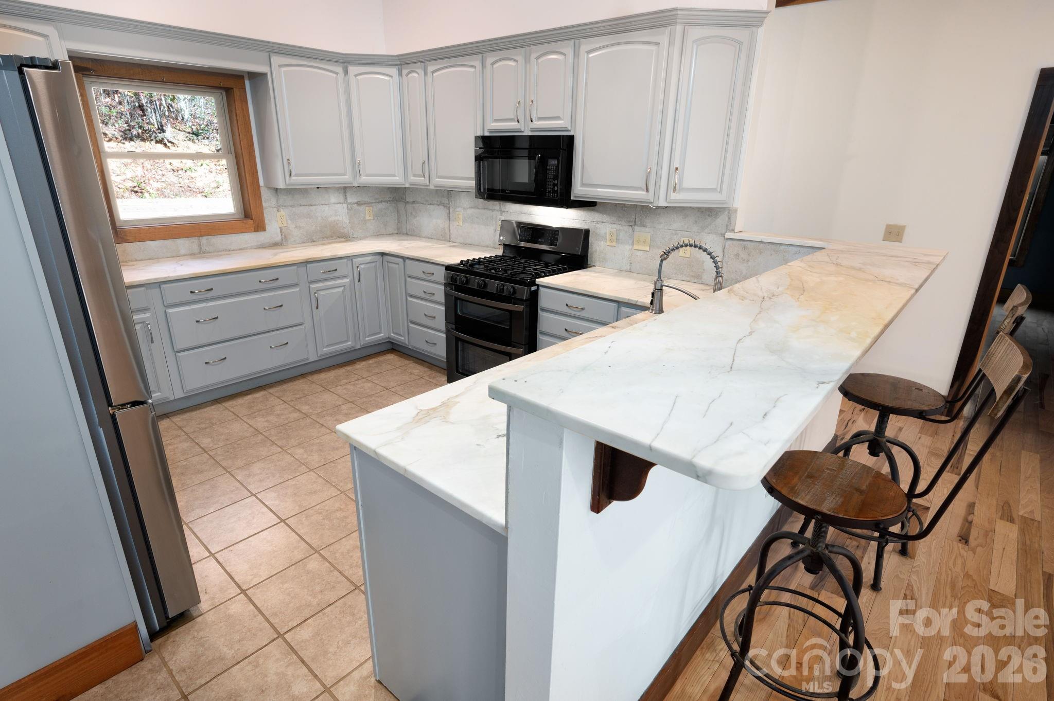 22 Faholoa Ridge Road Black Mountain, NC 28711 - Photo 27 of 47 a kitchen with stainless steel appliances granite countertop a stove a sink and a microwave