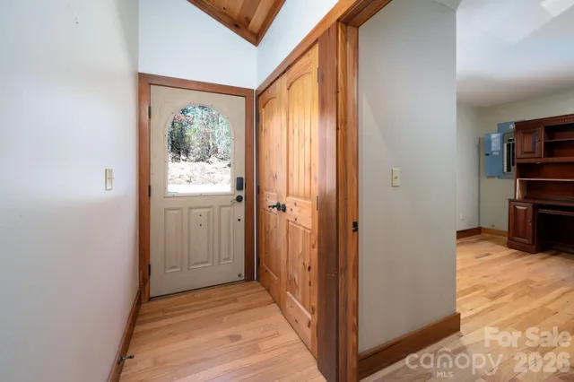 a view of a hallway with wooden floor and a bathroom