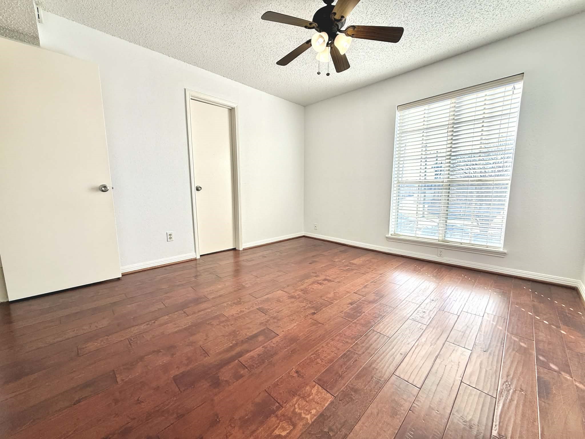 12100 Overbrook Lane, Unit 17D Houston, TX 77077 - Photo 13 of 22 an empty room with wooden floor fan and windows