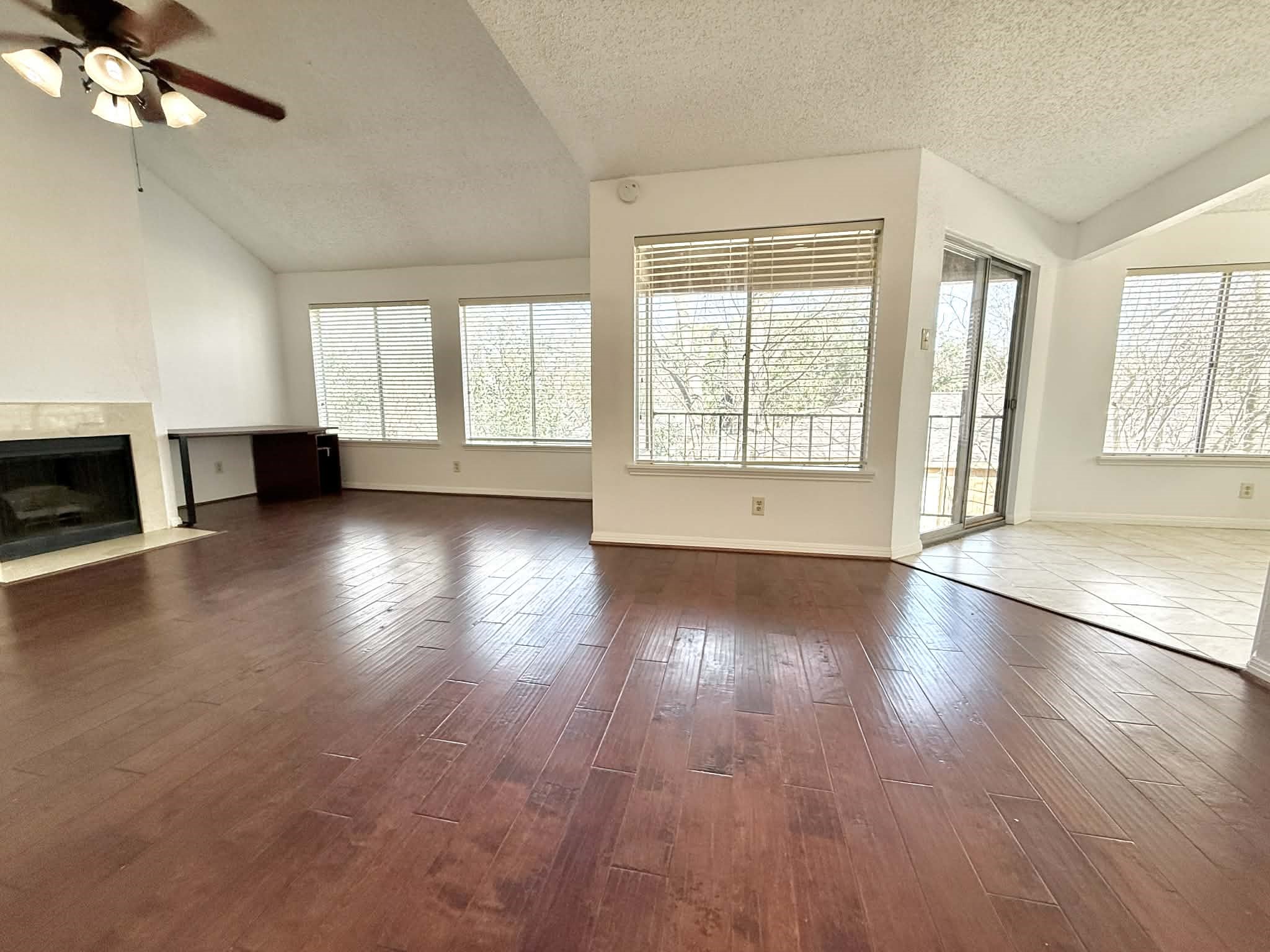 12100 Overbrook Lane, Unit 17D Houston, TX 77077 - Photo 2 of 22 an empty room with wooden floor fireplace and windows