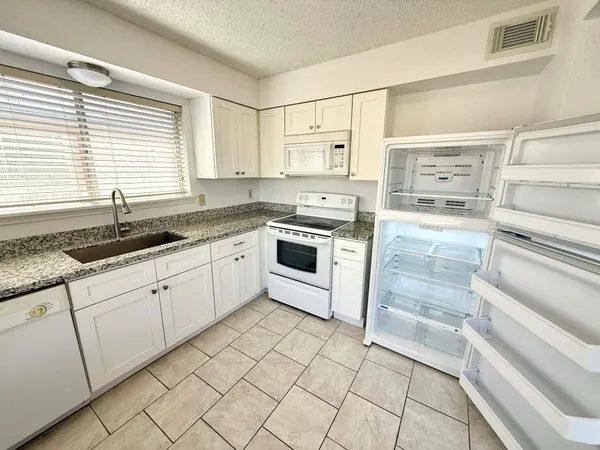 a kitchen with a sink stove and cabinets