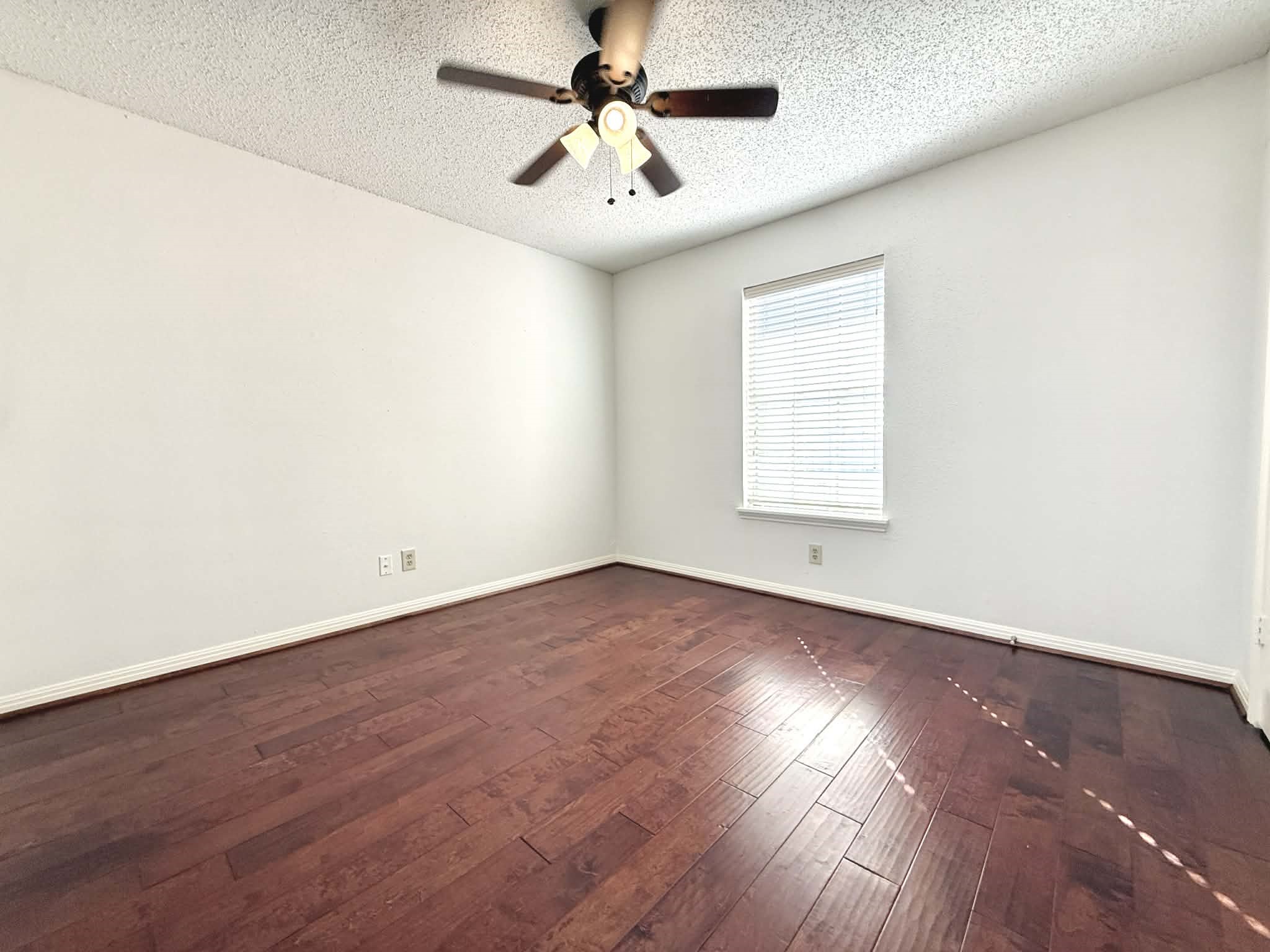 12100 Overbrook Lane, Unit 17D Houston, TX 77077 - Photo 9 of 22 an empty room with wooden floor and windows