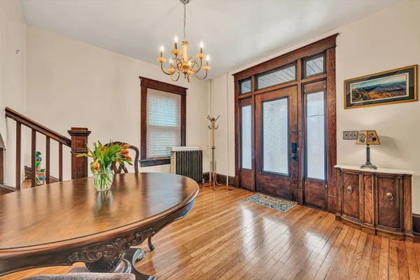 a dining room with furniture a chandelier and wooden floor