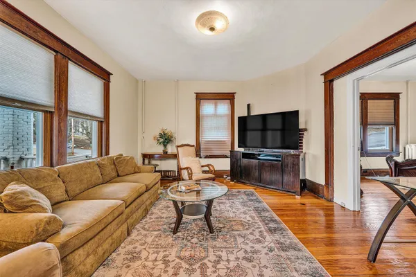a living room with furniture wooden floor and a flat screen tv