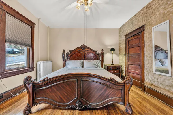 a bedroom with a bed and wooden floor