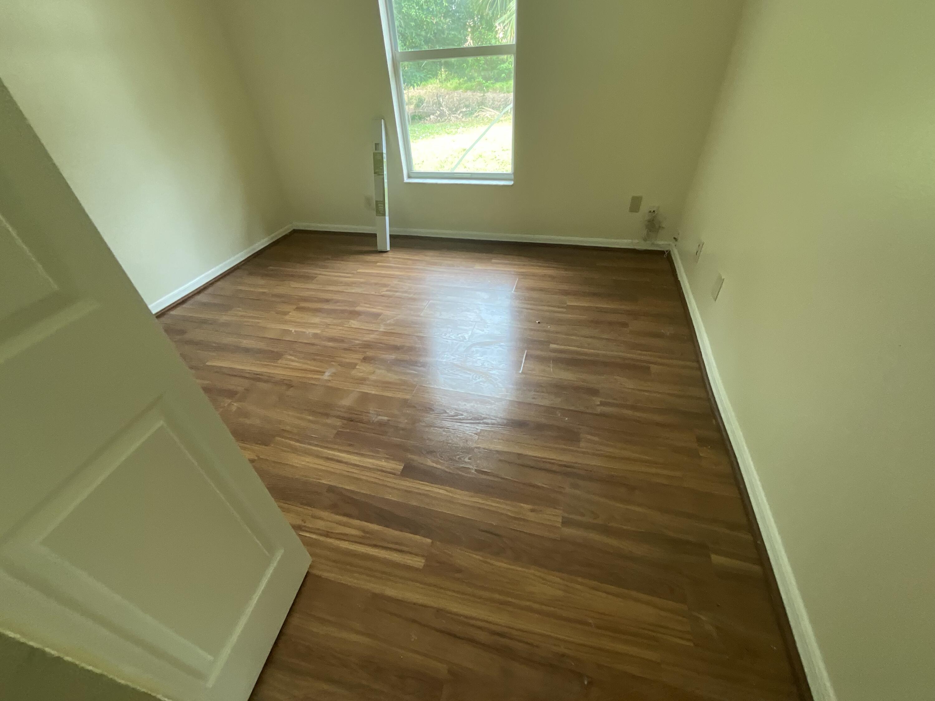 1002 Southwest Romaine Lane Port St. Lucie, FL 34953 - Photo 16 of 26 a view of a room with wooden floor and window