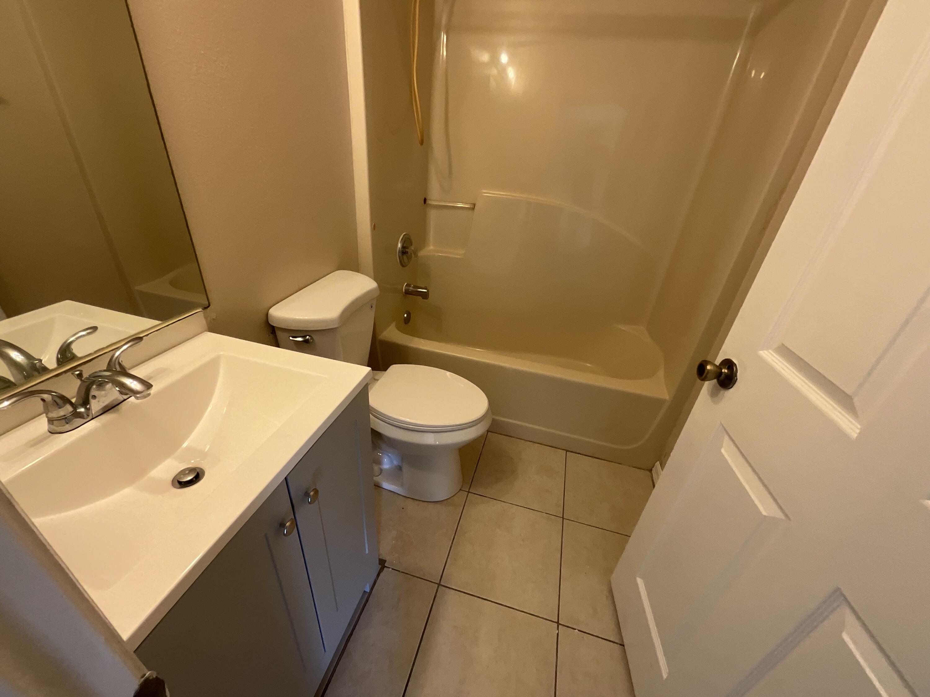 1002 Southwest Romaine Lane Port St. Lucie, FL 34953 - Photo 19 of 26 a bathroom with a sink and a mirror
