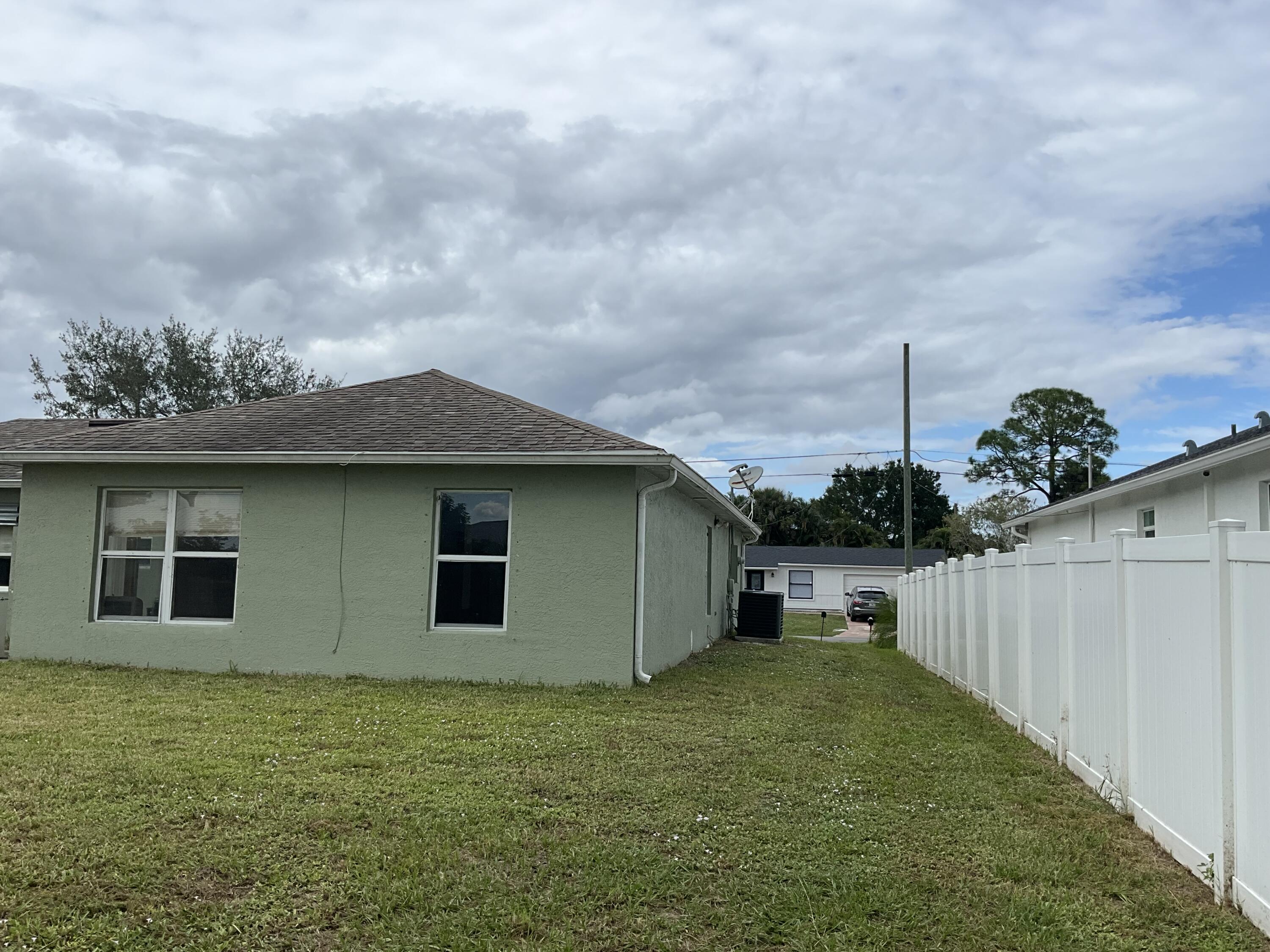 1002 Southwest Romaine Lane Port St. Lucie, FL 34953 - Photo 2 of 26 a backyard of a house with lots of green space