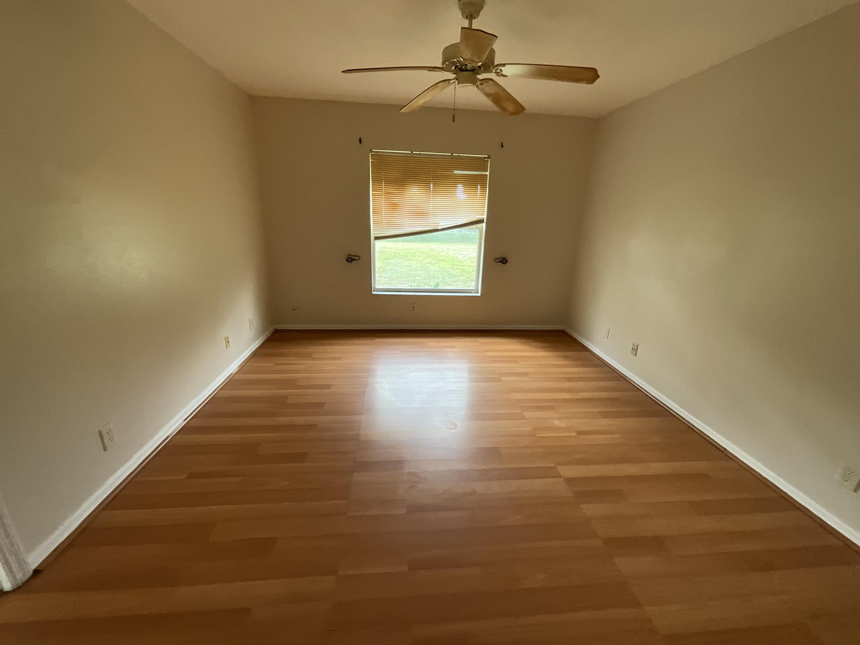 1002 Southwest Romaine Lane Port St. Lucie, FL 34953 - Photo 24 of 26 an empty room with windows and fan