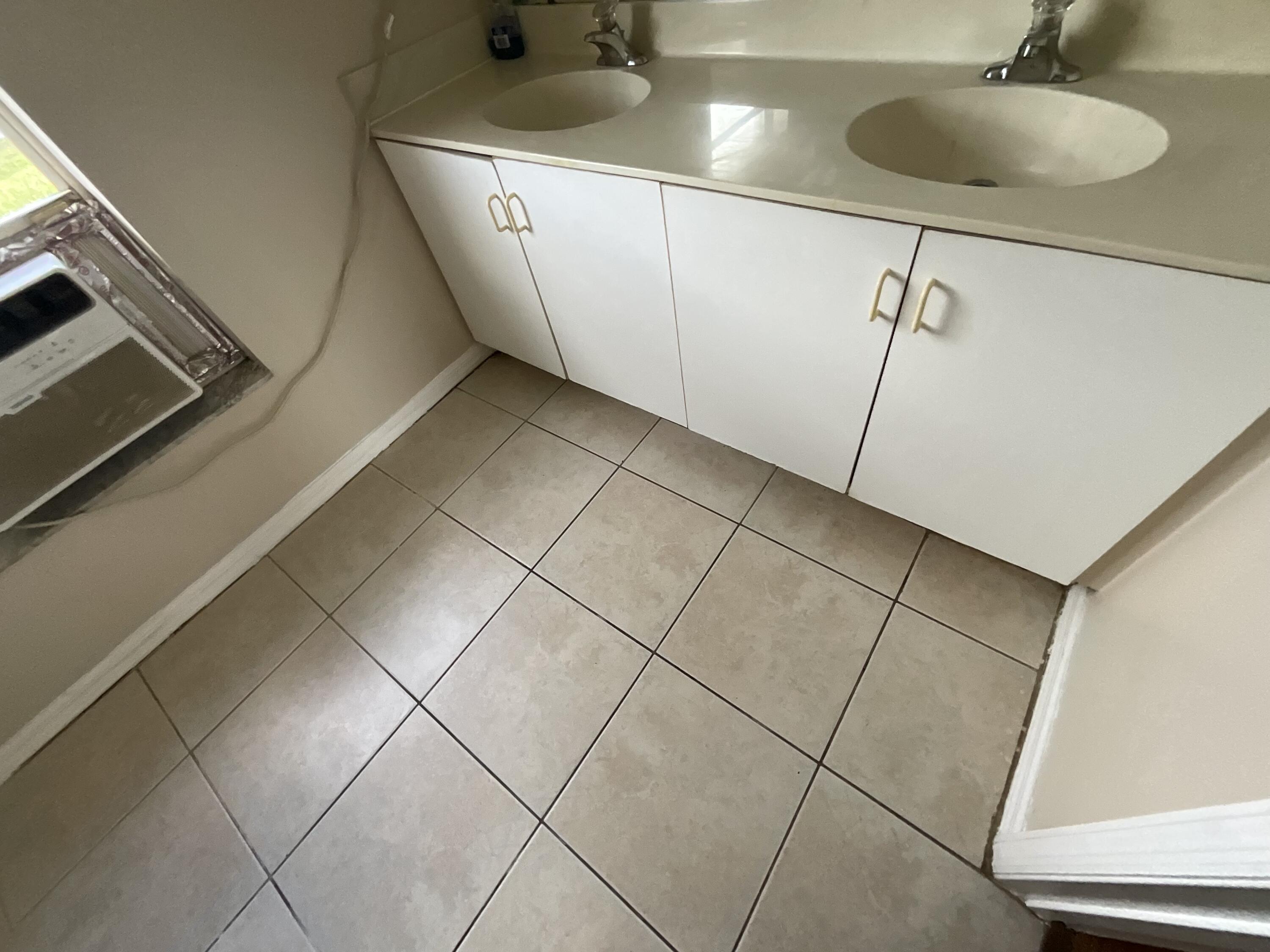 1002 Southwest Romaine Lane Port St. Lucie, FL 34953 - Photo 26 of 26 a bathroom with a sink and a mirror