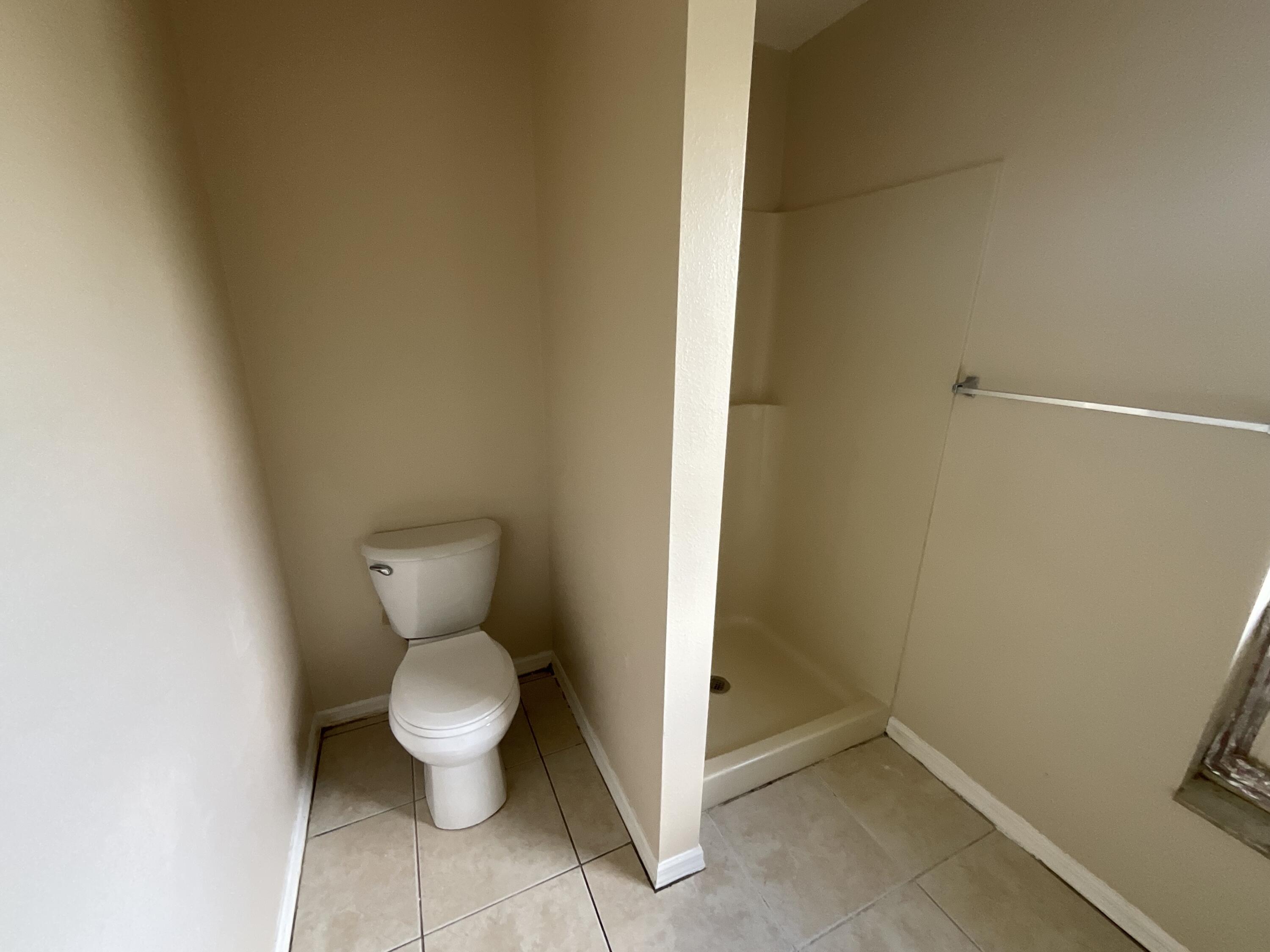 1002 Southwest Romaine Lane Port St. Lucie, FL 34953 - Photo 5 of 26 a white toilet sitting next to a white wall