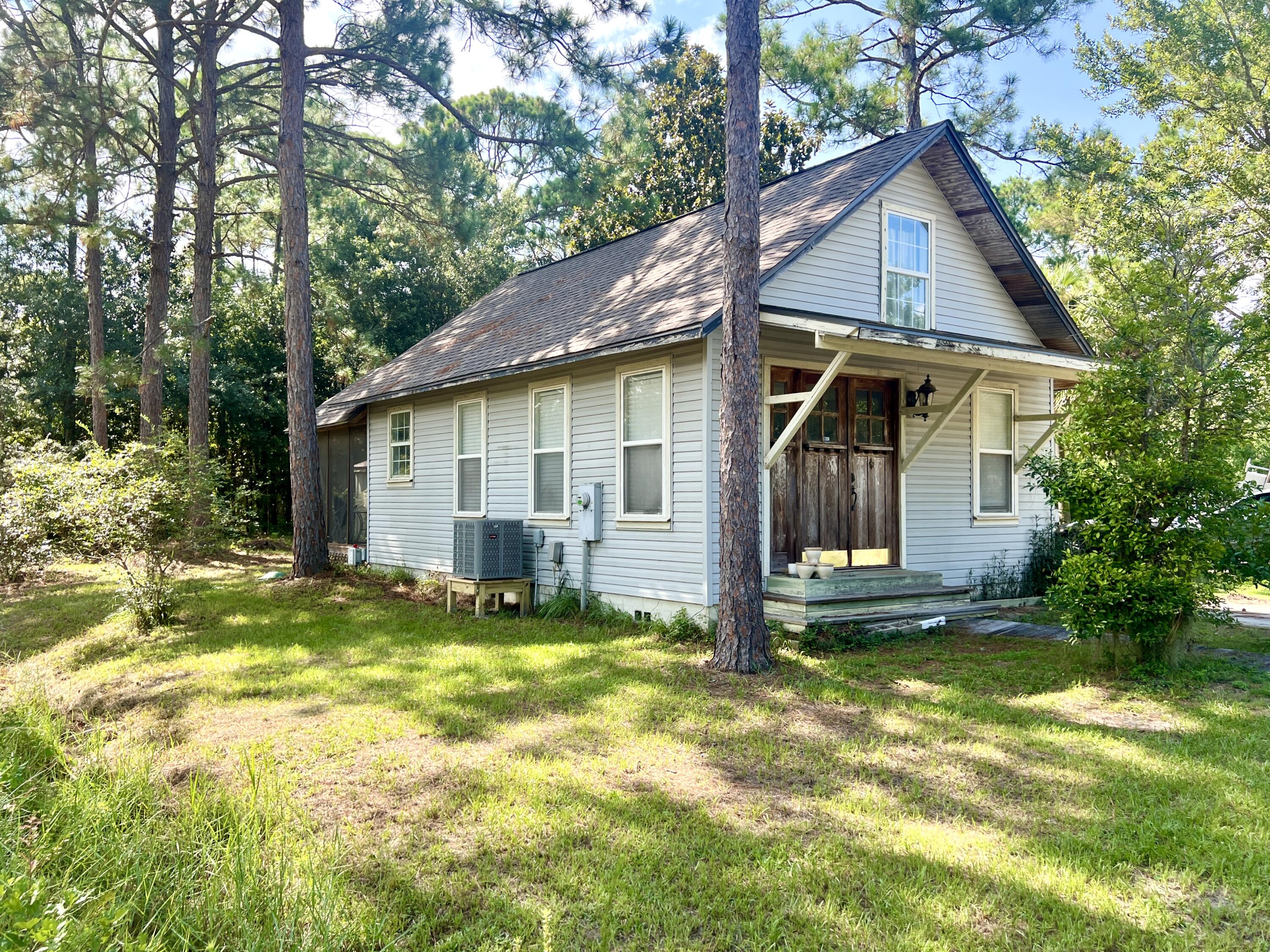 a view of a house with big yard and large tree