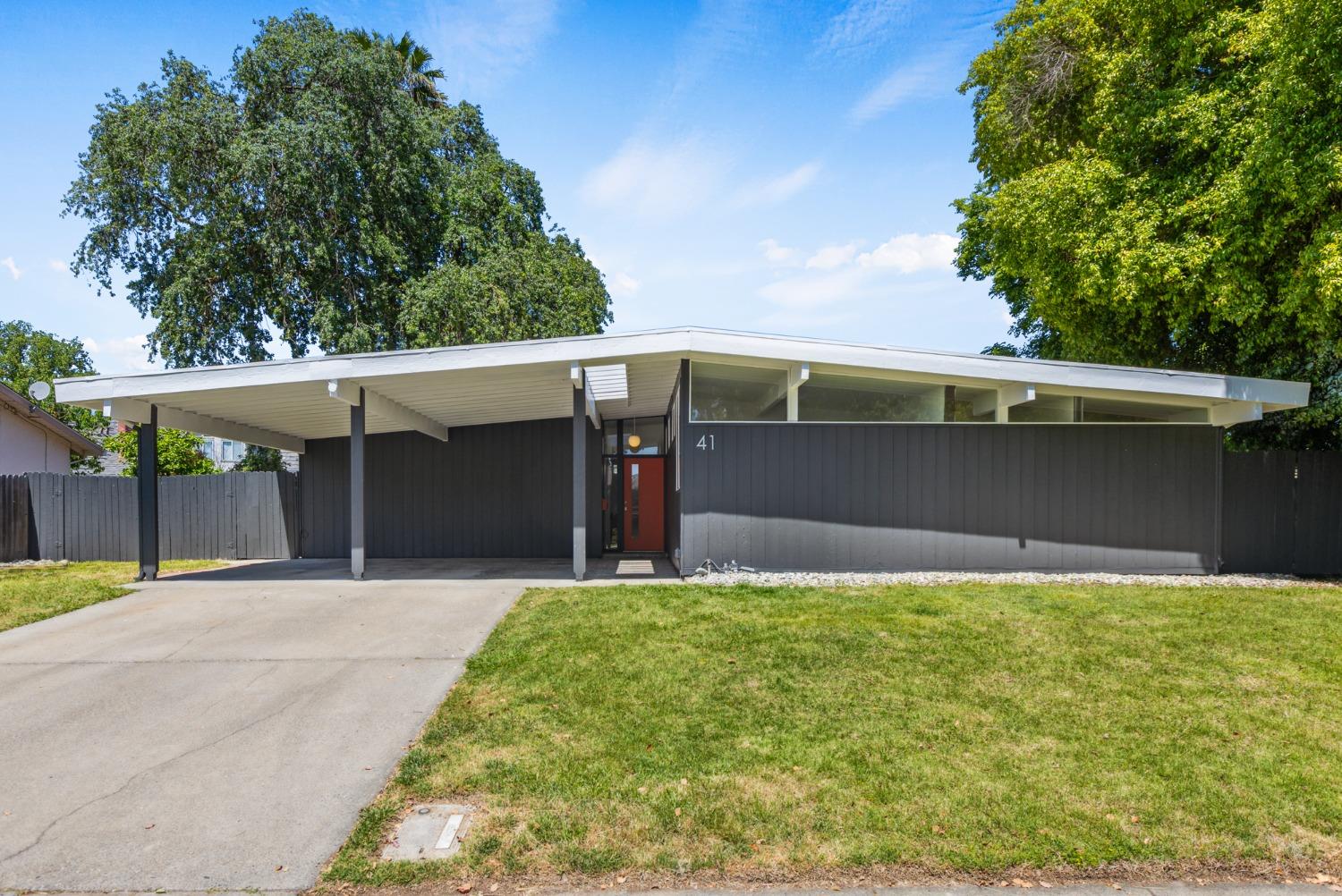 a front view of house with yard and trees in the background