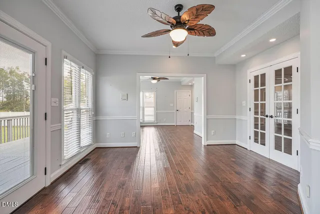 an empty room with windows and ceiling fan